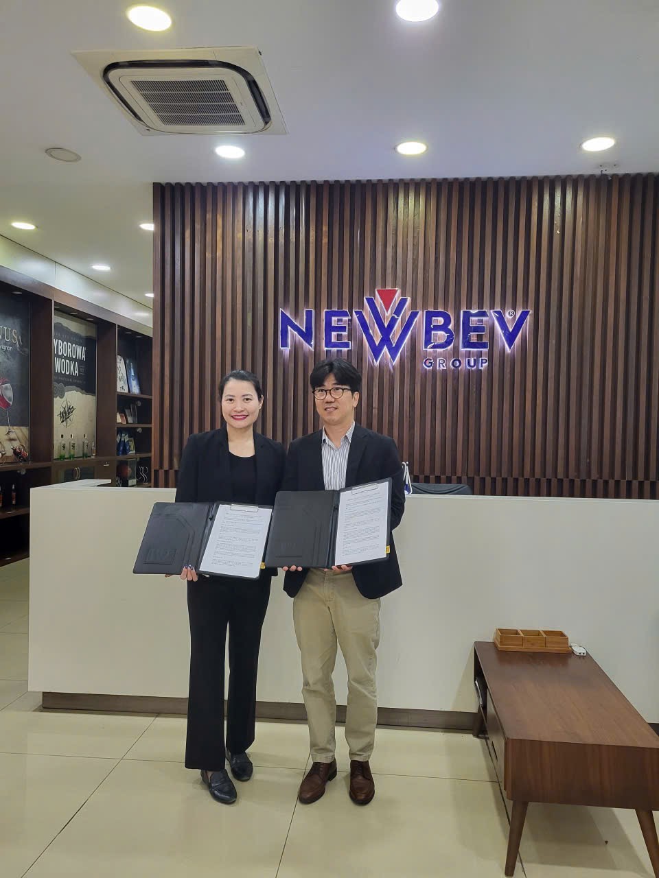 메타빈스와 NEWBEV Group 관계자가 서명한 업무협약서를 들고 기념 촬영한 모습
